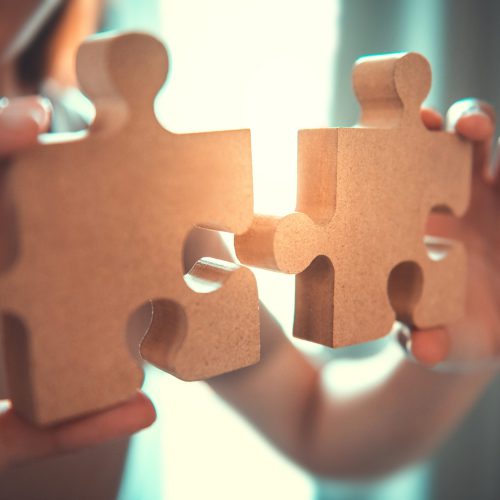 Silhouette of woman connecting jigsaw puzzle with sunlight effec Silhouette of woman connecting jigsaw puzzle with sunlight effec